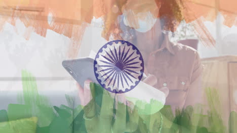 animation of woman wearing face mask in office over indian flag