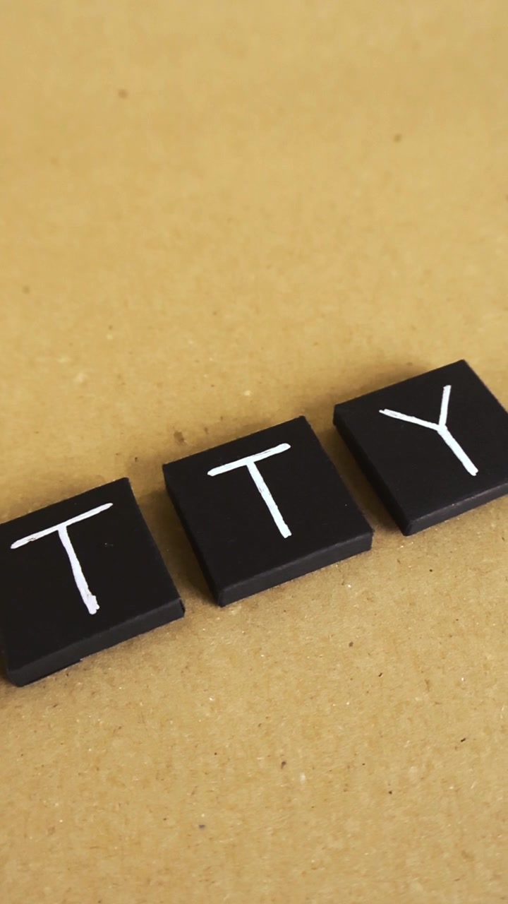 Black square tiles with handwritten letters spelling out the word fatty, sliding over a rustic cardboard background, representing an unhealthy lifestyle, body shaming, and weight gain