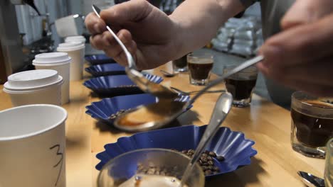 cucharas que se enjuagan durante el proceso de prueba de cata de café, cámara lenta de cerca