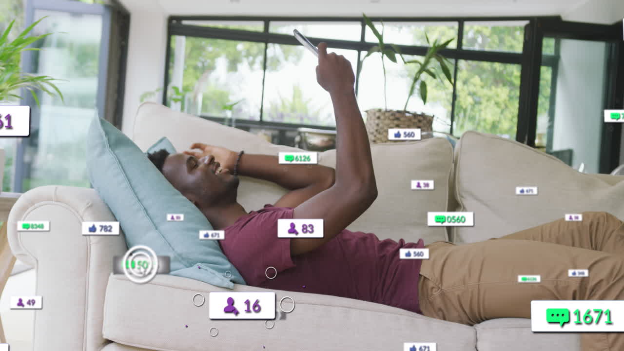 animación de barras de notificación sobre hombre afroamericano acostado en el sofá y desplazamiento en el teléfono celular
