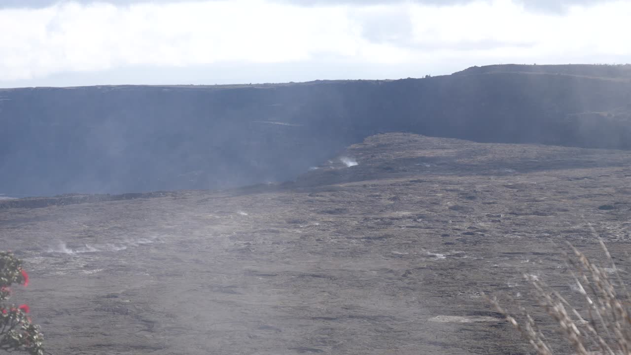 cráter de kilauea en hawaii con vapor y paisajes volcánicos al sol con nubes y cielo azul