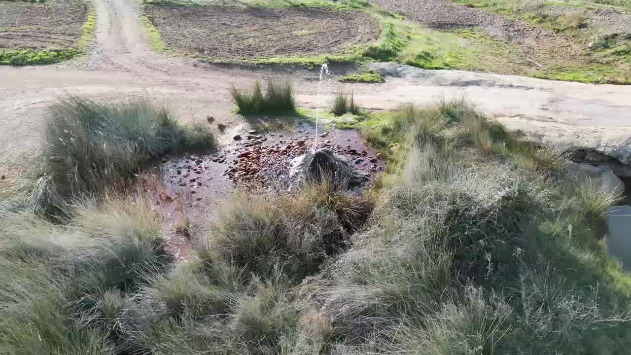 geyser at Fuendejalon Spain with spurting water and iron deposits.