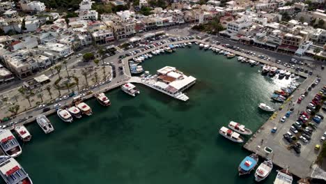 drone dolley tilt shot over the busy harbor of elounda at daylight in greece