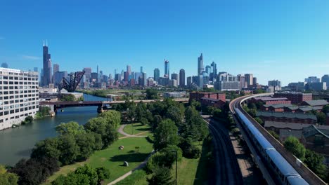 chicago l train passing through park and view of chicago downtown skyline