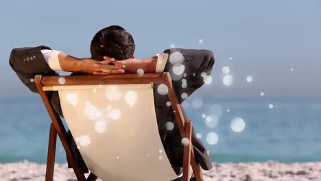 -caucasian-man-sitting-on-deck-chair-in-front-of-sea-with-bubble-light-animation