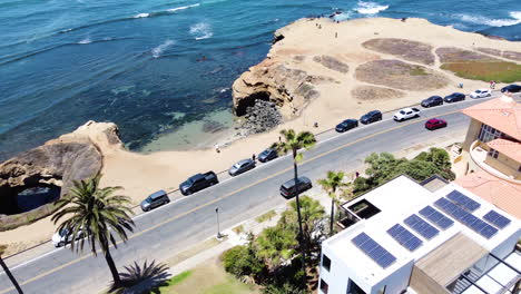 unidad costera tropical con vehículos, personas y tejados con paneles solares