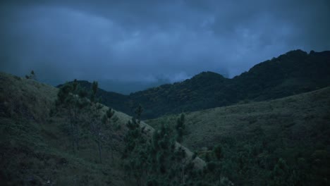 laderas de una montaña con nubes oscuras en el fondo