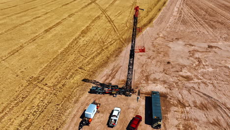 circling above the oil drilling site in the field. drone footage around the truck with derrick and few other vehicles.