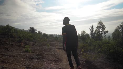 A-tracking-shot-of-the-silhouette-of-an-African-man-as-he-walks-into-the-morning-sun-while-on-a-bush-path-in-rural-Africa