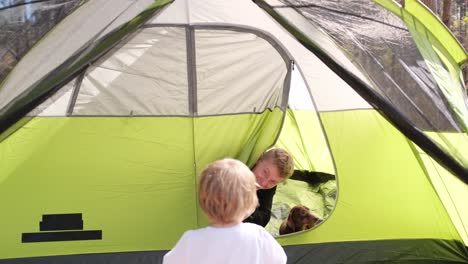 man children and dog resting in tent camping in the forest man children and dog resting in tent camping in the forest