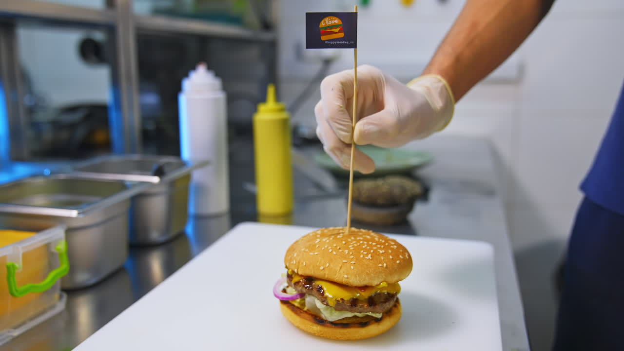 Fast food. Macro view of burgers, french fries, cola. Hands of a person make a hamburger from buns, cutlets, lettuce, cucumber, tomatoes, onions and sauces. Beautiful background.