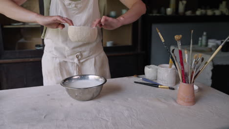 woman pottery artist dipping a bowl