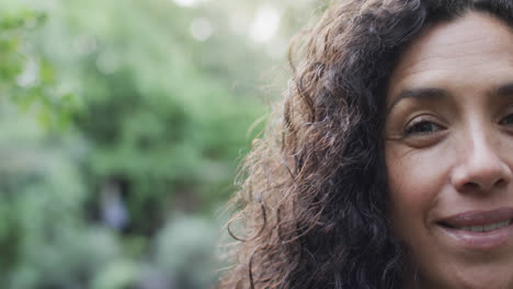 Medio-Retrato-De-Una-Mujer-Birracial-Feliz-En-Un-Jardín-Soleado-Con-Espacio-Para-Copiar,-Cámara-Lenta