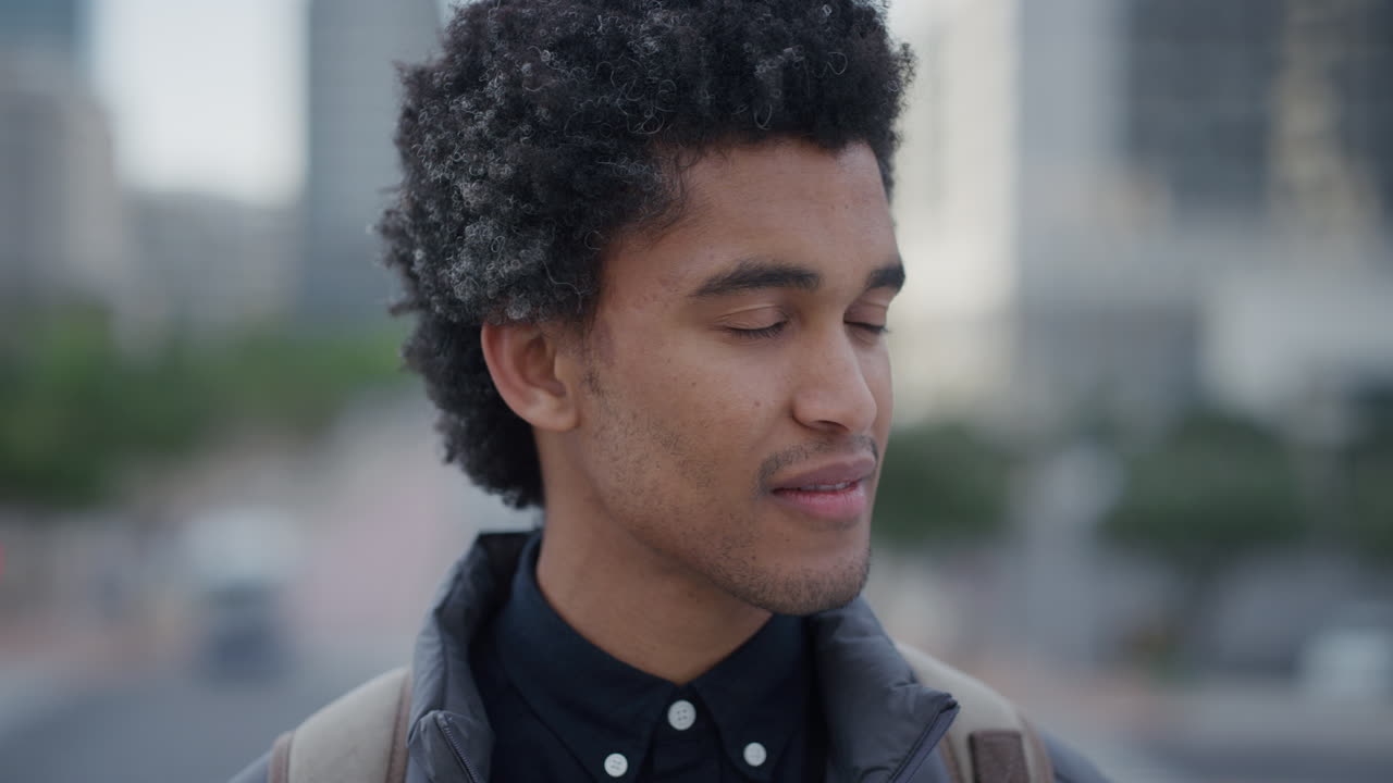 retrato de cerca exitoso joven hombre de negocios de raza mixta gira la cabeza buscando expresión confiada en la ciudad masculino étnico de moda peinado afro
