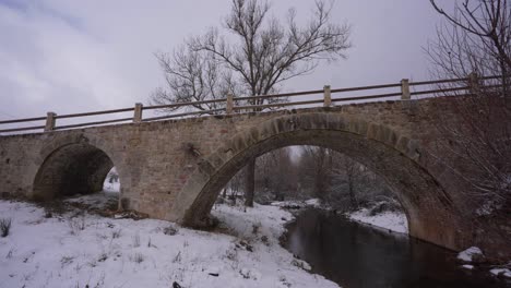 hermoso puente antiguo construido con piedra de la edad media en un terreno nevado de invierno en albania