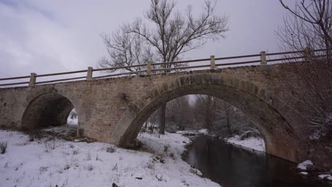 beautiful old bridge built by stone from middle age on a winter snowy bacground in albania