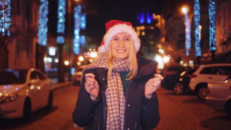 a beautiful woman in a santa claus hat walks at night on christmas