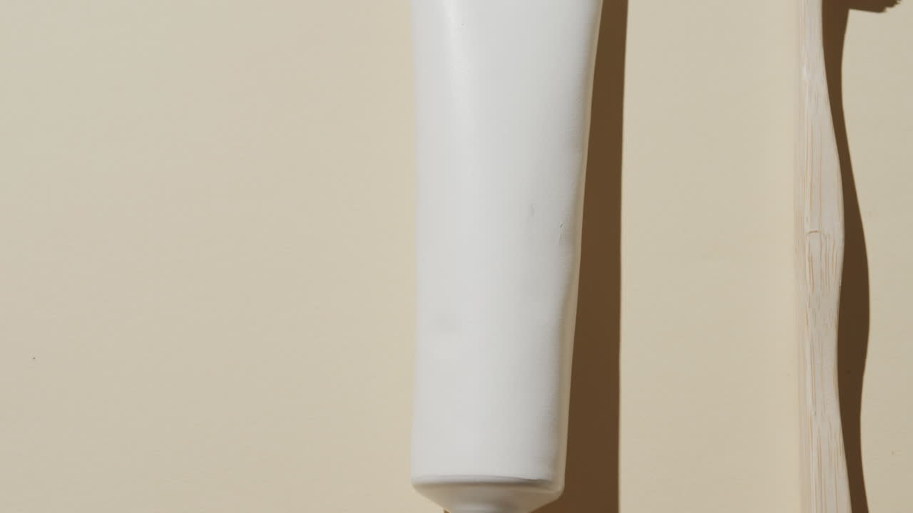 Primo piano di spazzolino da denti e dentifricio su sfondo beige con spazio per il testo.