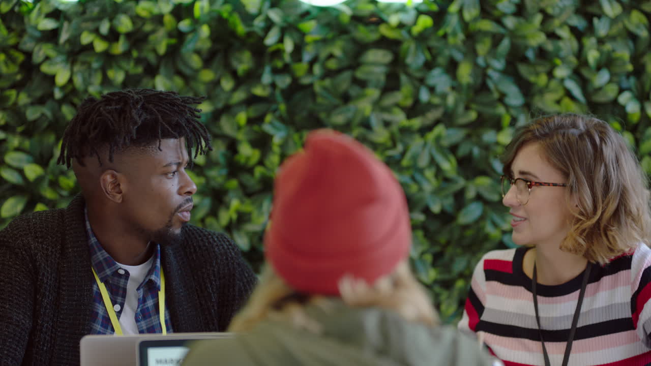 grupo de jóvenes empresarios discutiendo ideas disfrutando de la conversación colegas compartiendo conexiones sociales lluvia de ideas en el lugar de trabajo sostenible de la oficina de inicio