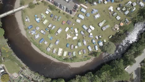 aerial view of camping tents, campervans and caravans on the riverbank of river avonmore in rathdrum, wicklow, ireland