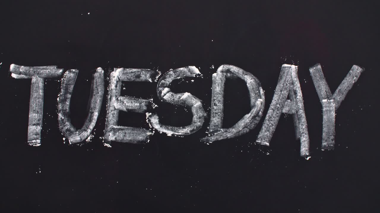 Word 'tuesday' written on the blackboard