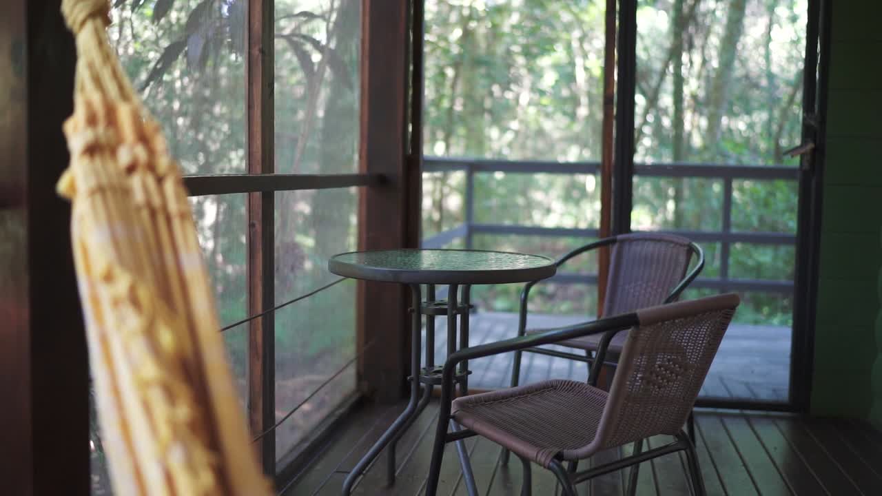 Wooden deck with table and two chairs in a tropical hotel room. Vacation rental. Argentina.