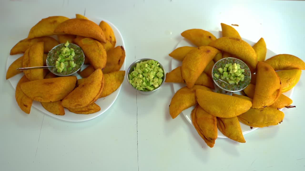 platos de empanadas recién cocinadas con salsa de guacamole - vista superior