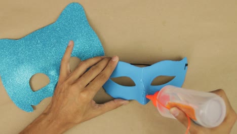 hands use liquid silicone to glue blue diamond foam to mask, catboy mask for carnival