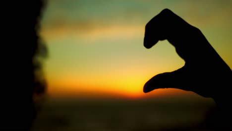 silhouette, love and heart hand with sunset clouds