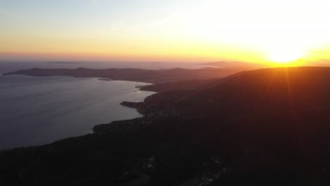 Puesta-De-Sol-Sobre-La-Ciudad-Balnearia-Cavaliere-Toma-Aérea-Silueta-De-Montañas