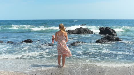 woman in a summer dress on a vacation in tenerife, standing on a beach