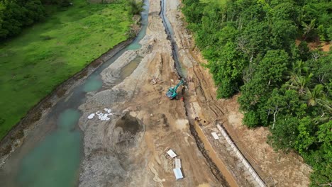 an excavator working on the road construction site near sto domingo in virac, catanduanes philippines. aerial shot
