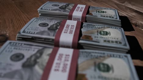 three stacks of 10000 american dollars banknotes in bundles lie on wooden table