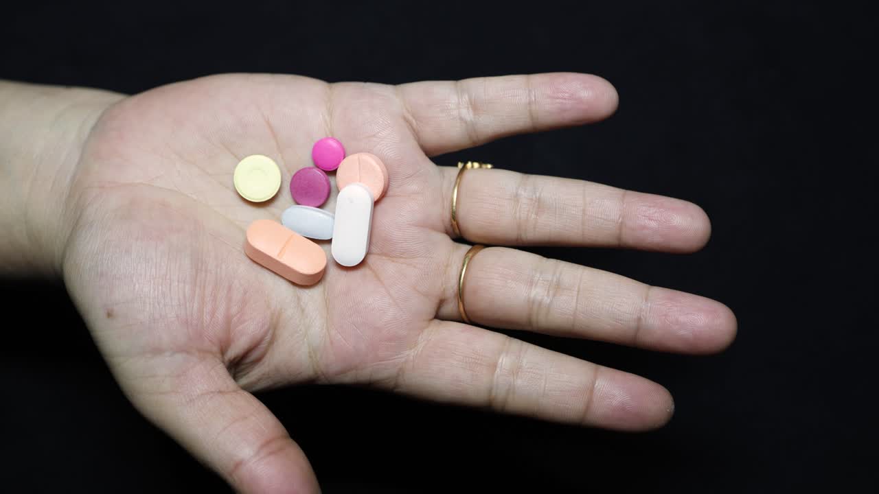 healthcare concept with adult hand and pills at indoor lighting