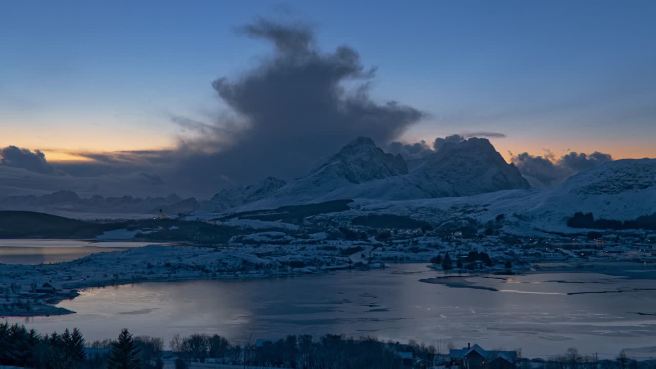 Bred engel af en vej gennem en frossen dal på en tåget vinterdag. Sneklædte bjerge og skyer. Time Lapse. Lofoten, Nordnorge
