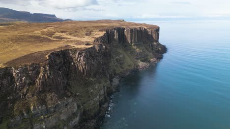 wide drone lifting shot of the high kilt rocks with autumn colored plain