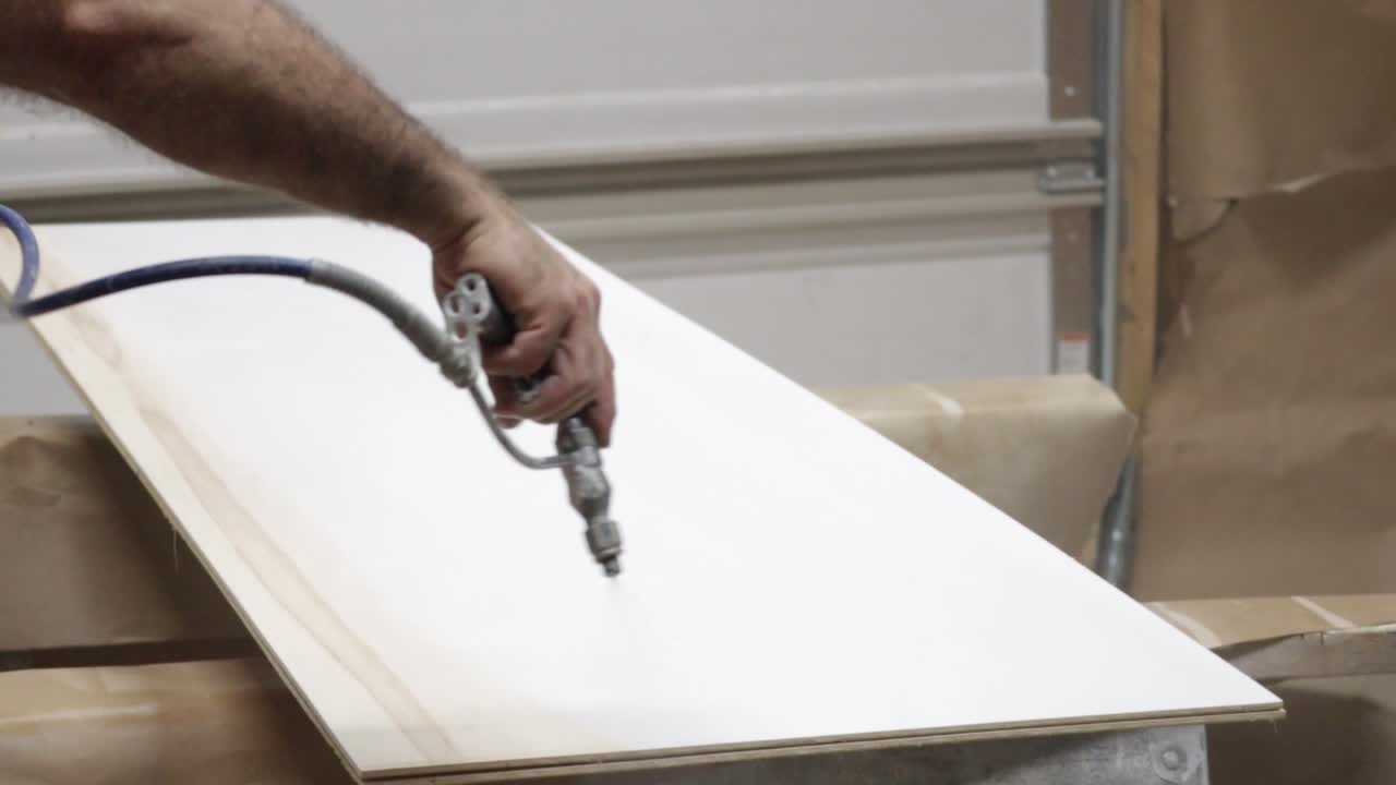 Man Painting Cabinet Pieces White
