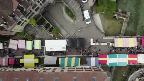 street vendors during farmer's market on annecy old town bridge, aerial drone top down