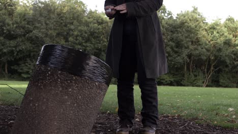 Woman-putting-rubbish-in-park-bin-medium-shot