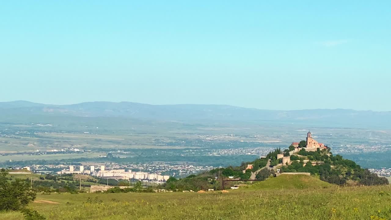 Panoramic panning view of Shavnabada monastery building in summer