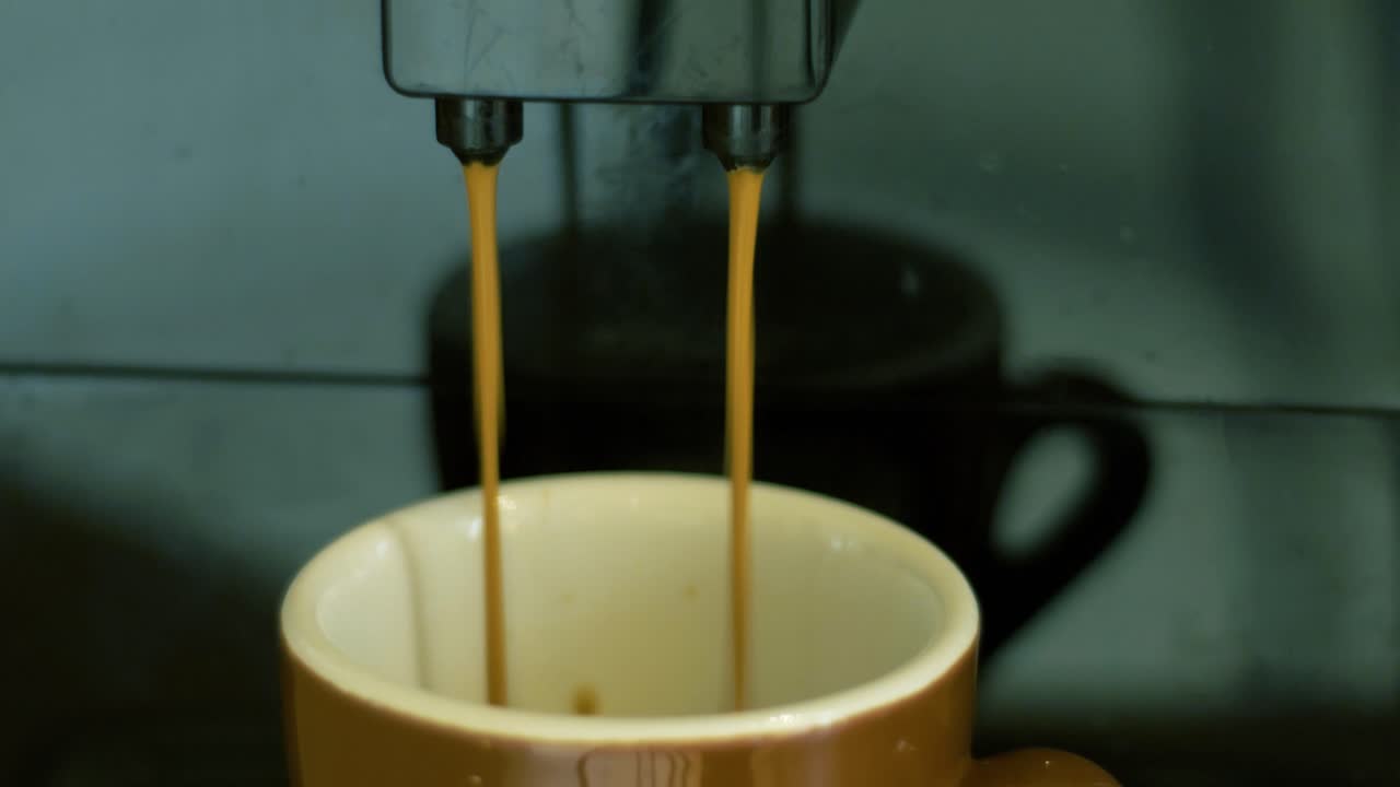 Still shot of an automatic coffee machine pouring black coffee