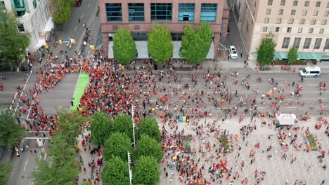 a political rally on the road in a big city urban centre, drone slide right view in uhd