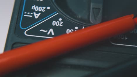 multimeter with probes and scale on white background macro