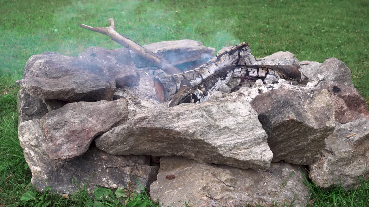 fuego de campamento en un sitio de campamento hecho de grandes rocas