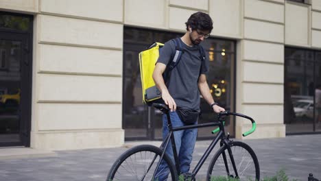 Ein-Kurier-Mit-Rucksack-Hält-An-Einer-Adresse-An.-Einzelheiten-Finden-Sie-Auf-Dem-Bestelleingang