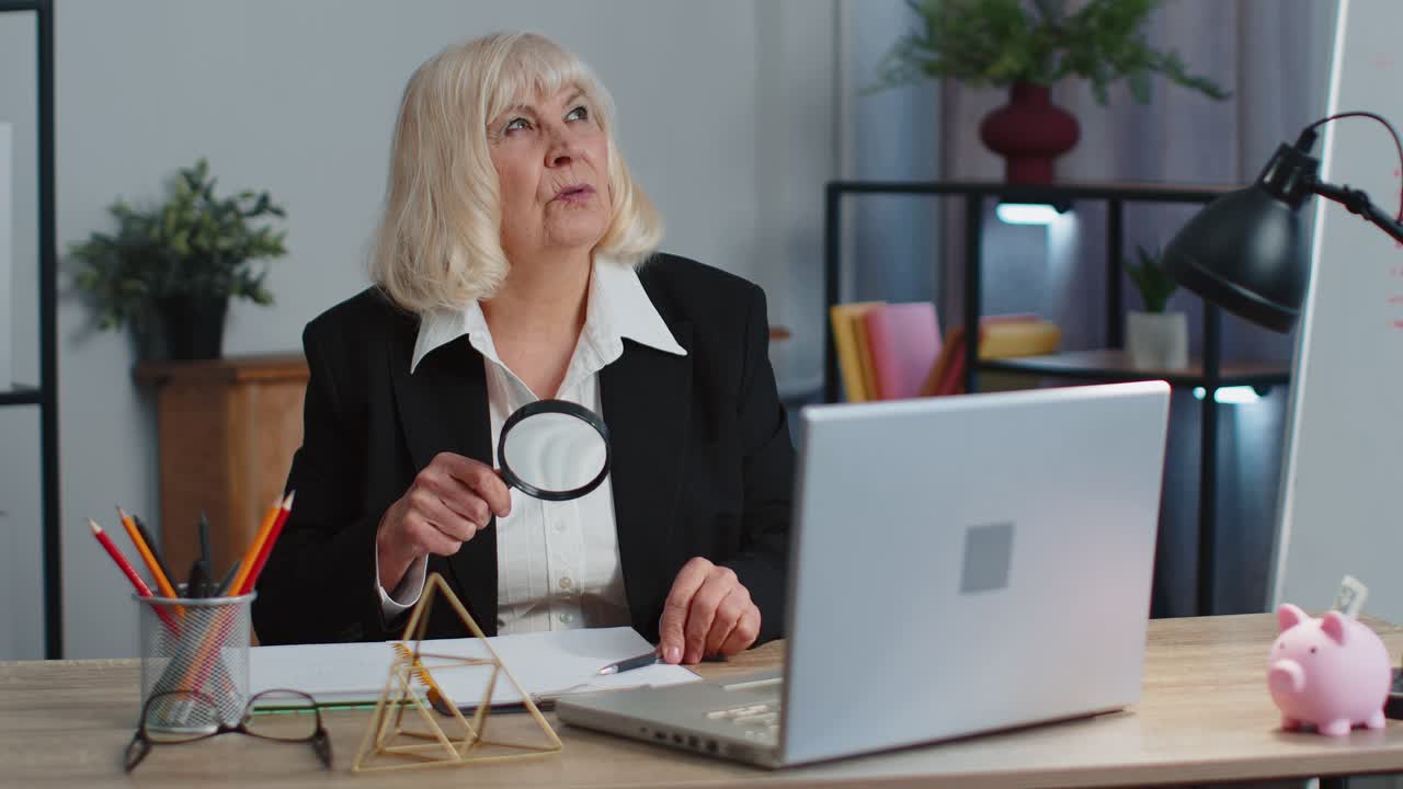Senior business woman looks through a magnifying glass investigate analyzing reading documents