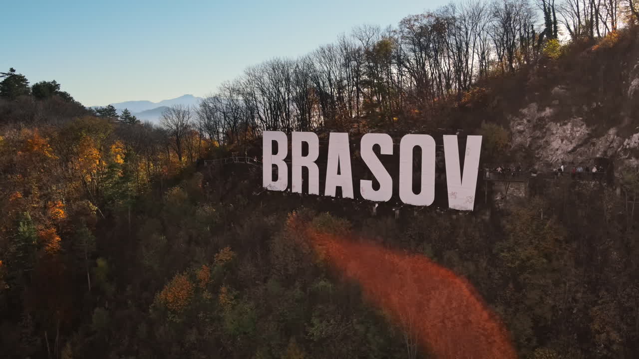 Scritta Brasov sulla cima della collina vicino alla città, alberi ingialliti, Romania