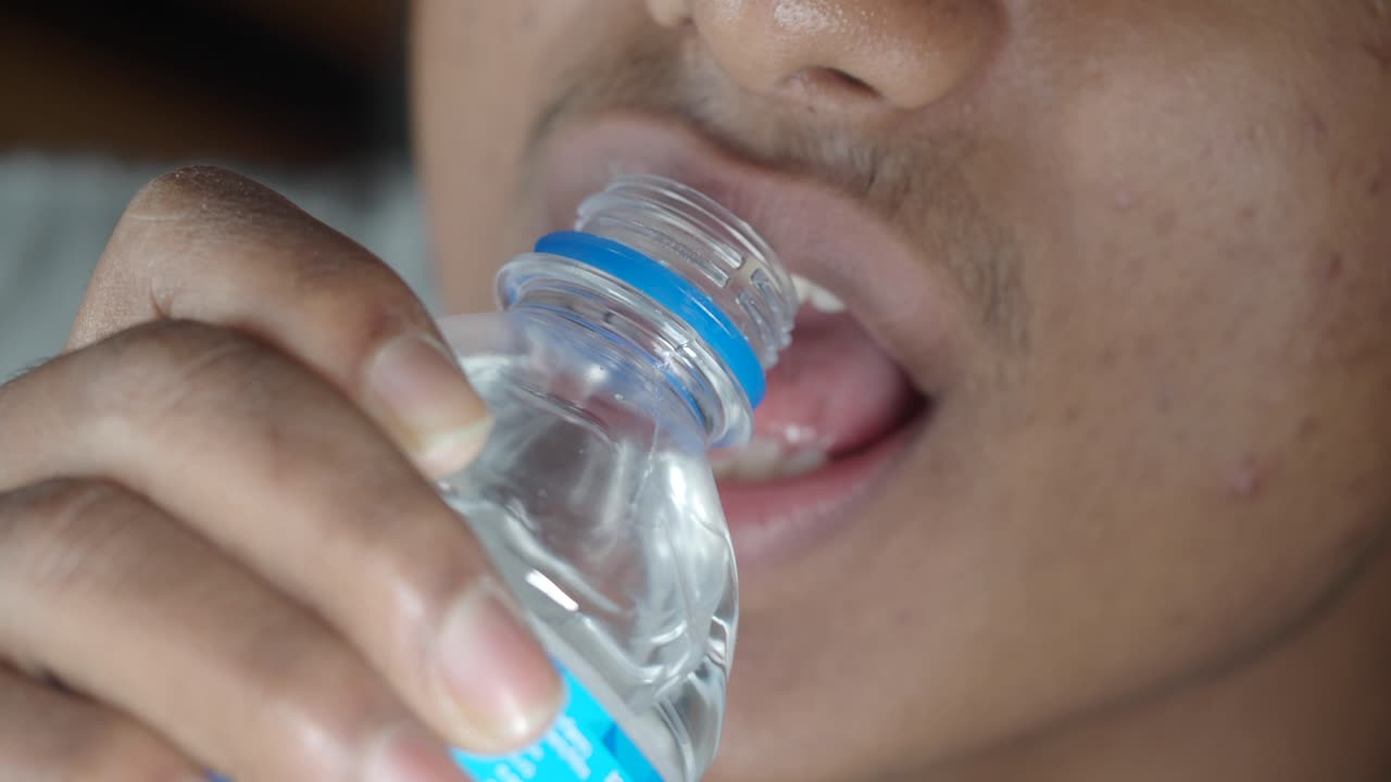 Close-up of a young man drinking water