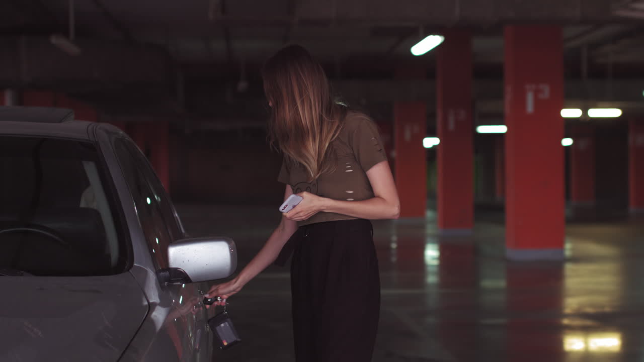 Woman opening car door in an underground parking garage
