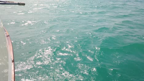 waves crash against the side of a boat on the azure sea, zakynthos island, greece